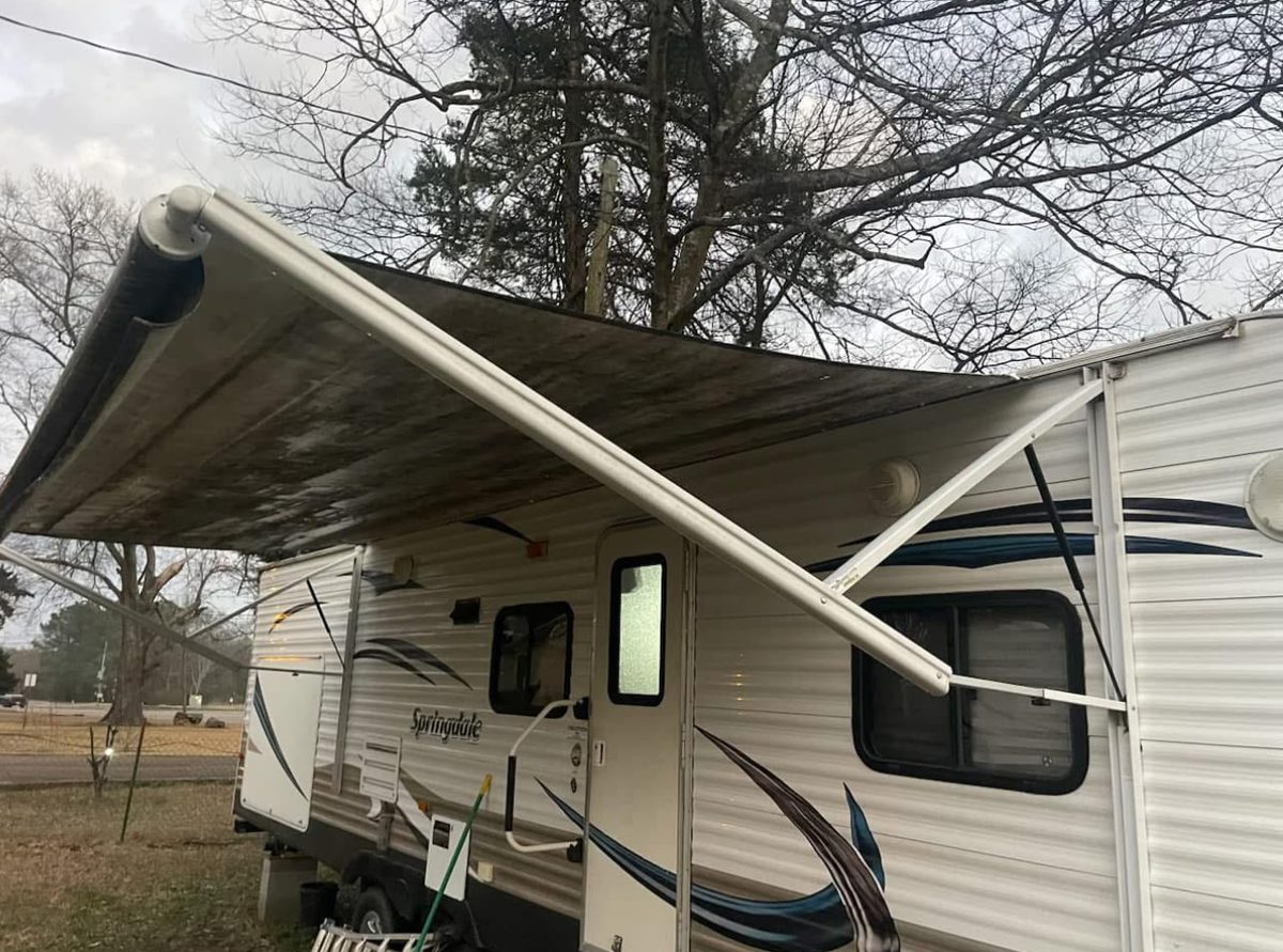 Old, worn and damaged awning on a Springdale camper before replacement